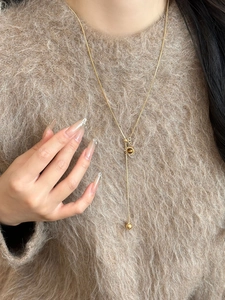 Macro detail of golden sun pendant with brown tiger eye stone on a sweater