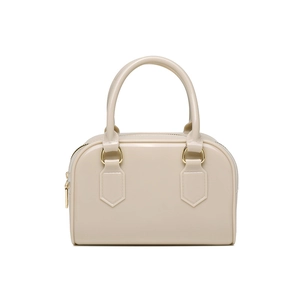 Detail of beige jelly boston bag with smooth finish and dual gold zippers on a white background