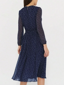 Vue arrière détaillée d'une robe longue bleu marine à pois avec manches longues et coupe ajustée