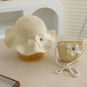 Close-up of kids straw sun hat and matching bag with floral lace and tulle bow