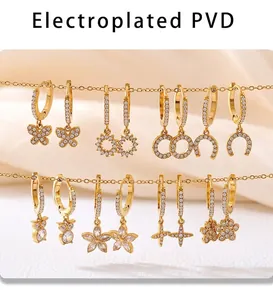 Close-up of PVD gold plated earrings with zircon butterfly and heart pendants