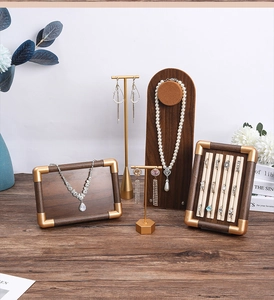 Detail of walnut wood jewelry display set with gold metal accents and ring holders