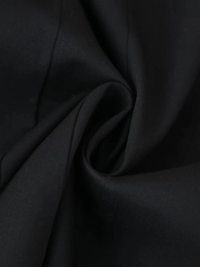 Gros plan sur la texture du tissu noir avec tissage fin et drapé élégant pour robe