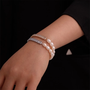 Detail view of gold and silver bracelets featuring cubic zirconia and freshwater pearls