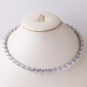 Detail view of heart-shaped zircon choker necklace on a beige display bust