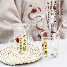 Détail d'un verre aurora avec calligraphie chinoise et paille en verre sur un sous-verre