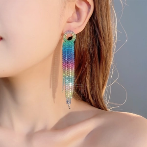 Macro close-up of long rainbow tassel earrings with colorful gradient rhinestones