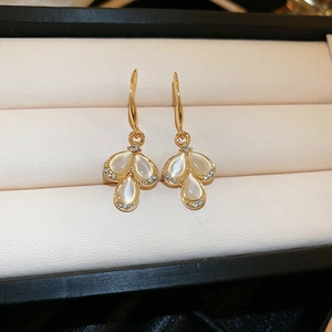 Detailed macro view of golden flower petal earrings with teardrop opal stones