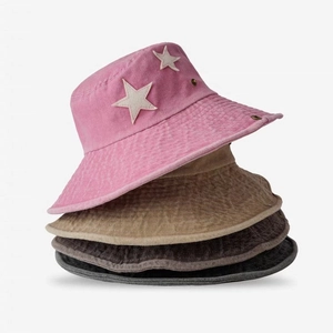 Detail of stacked vintage cotton cowboy hats in pink and khaki with star patches