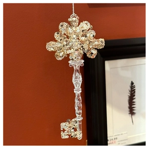 Macro detail of acrylic Christmas key ornament with sparkling champagne gold sequins