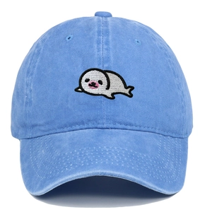 Close-up of cute seal embroidery on washed blue cotton baseball cap with ventilation eyelets