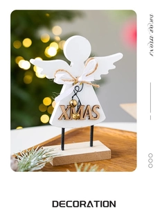 Macro detail of wooden Christmas angel ornament with XMAS lettering and golden bells