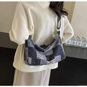 Gros plan du sac bandoulière en denim avec des textures de patchwork bleu et noir