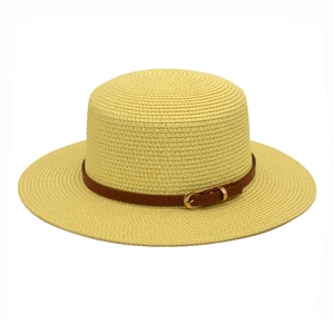 Detailed texture of flat top boater hat with woven straw and brown leather band buckle