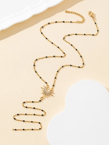 Detail of gold starburst necklace with black beads and sparkling zircon stones