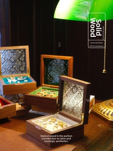 Detail of walnut wood jewelry box with embossed glass lid and velvet interior lining