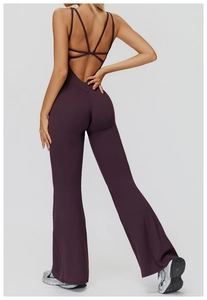 Detail of dark purple flared yoga jumpsuit featuring crisscross back straps and flare legs