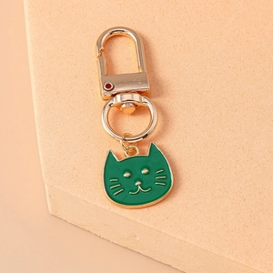 Cute green enamel cat head keychain with gold metal ring on geometric props