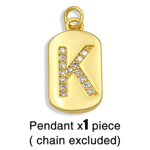 Detail of gold K-letter pendant with micro-paved cubic zirconia on a white background