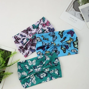 Three wide elastic headbands with butterfly prints in purple, blue, and green colors