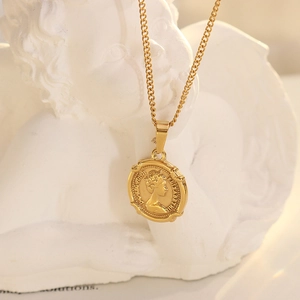 Vintage gold Cuban chain necklace with Queen Elizabeth II coin pendant on a white statue