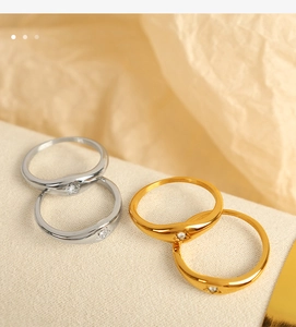 Detailed close-up of oval gold and silver rings with zircon star inlay on soft fabric