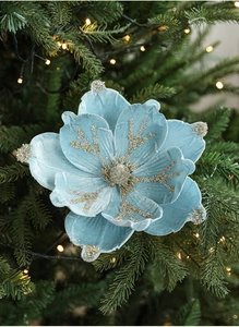 Detail of light blue flocked magnolia flower with glitter on a Christmas tree branch