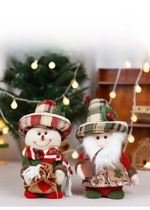 Detailed view of plush Christmas dolls with retro plaid hats in a cozy holiday setting