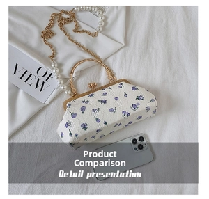 Detail of floral embroidery fabric and pearl handle on this vintage shell chain bag