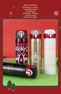 Close-up of stainless steel Christmas vacuum flasks with flip-top lids and festive patterns
