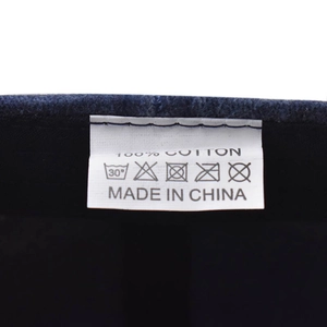 Detail view of cotton baseball cap washing label showing 100% cotton and care instructions