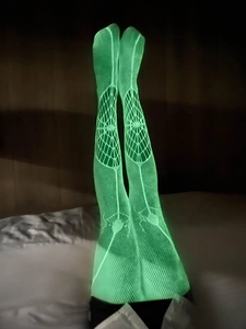 Bas résille vert fluo avec motifs d'araignées brillants dans le noir pour Halloween