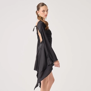 Detail of a black satin backless dress with a criss-cross tie and asymmetric hemline