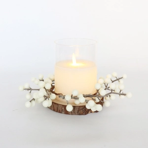 Couronne de baies blanches avec bougie pilier dans un verre sur socle en bois rustique