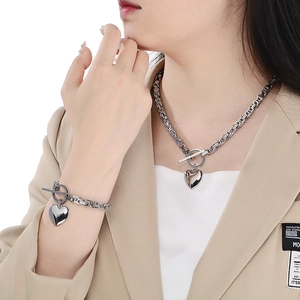 Polished silver heart pendant necklace and bracelet set with toggle clasp shown on model