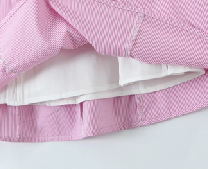 Detailed close-up of pink and white striped cotton fabric with white lining and stitching