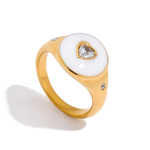 Close-up of gold stainless steel ring featuring white enamel surface and heart zircon