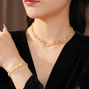 Détails d'un ensemble de collier et bracelet dorés de luxe avec zircons carrés sur modèle