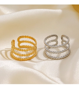 Close-up of triple-layer beaded line rings in gold and silver on silk fabric