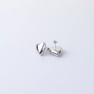 Detailed macro view of polished silver heart-shaped stud earrings in stainless steel