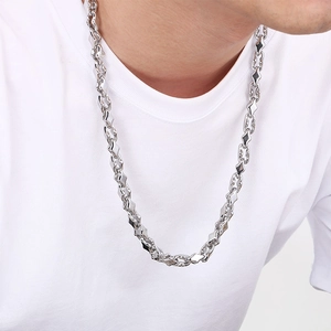 Close-up of geometric diamond-link stainless steel necklace worn on a model's neck