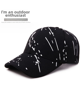 Detailed view of black baseball cap with artistic white splatter graffiti pattern