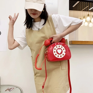 Detailed view of creative red patent leather crossbody bag in vintage telephone shape
