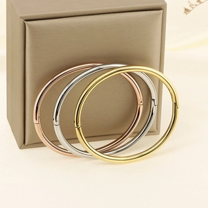 Polished minimalist 4mm bangles in gold, silver, and rose gold finishes on silk background