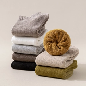 Pile of colorful cotton sports ankle socks in beige, grey, and olive green shades