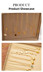 Close-up of golden titanium steel heart and butterfly pendant necklaces on a jewelry box