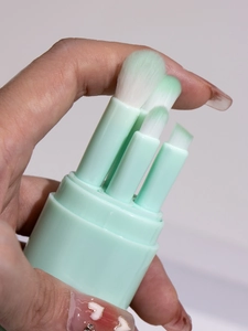 Close-up of portable 4-in-1 mint green makeup brush set with gradient bristles