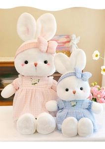 Detail of large pink and small blue floral dress plush rabbits in a home setting