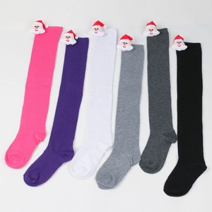 Detail of colorful knitted Christmas socks with 3D Santa Claus plush toy decorations