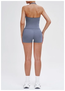 Back view of gray-blue halter yoga set showing cross-back top and tight sports shorts